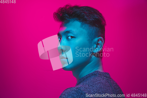 Image of Portrait of a guy with colorful neon light on pink background - cyberpunk concept