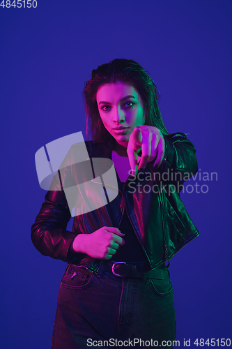 Image of Caucasian woman\'s portrait isolated on blue studio background in neon light