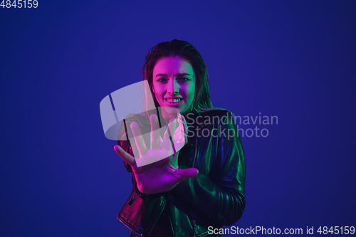Image of Caucasian woman\'s portrait isolated on blue studio background in neon light