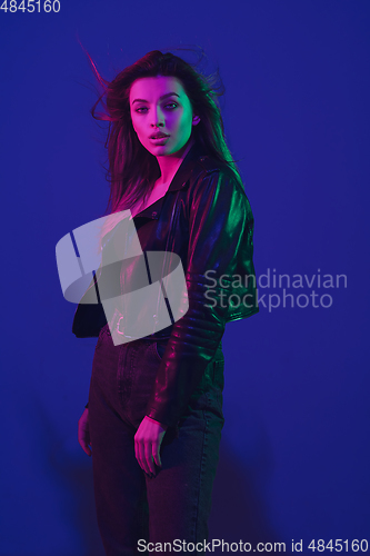 Image of Caucasian woman\'s portrait isolated on blue studio background in neon light