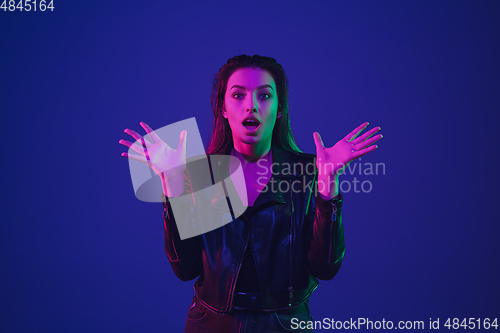 Image of Caucasian woman\'s portrait isolated on blue studio background in neon light