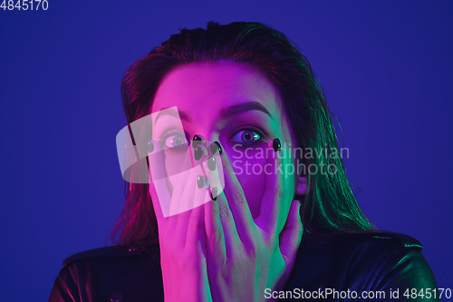 Image of Caucasian woman\'s portrait isolated on blue studio background in neon light