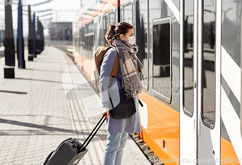 Image of woman in protective face mask at railway station