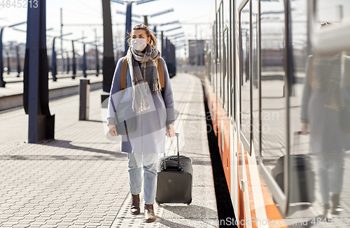 Image of woman in protective face mask at railway station