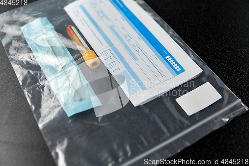 Image of beaker with test, cotton swab and medical report