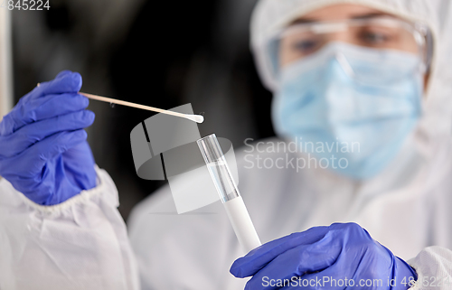 Image of scientist holding beaker with coronavirus test