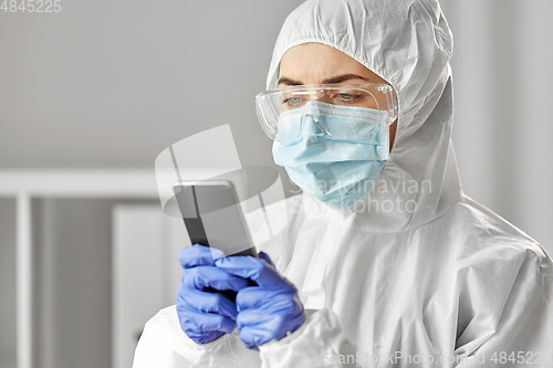 Image of doctor in protective wear with smartphone