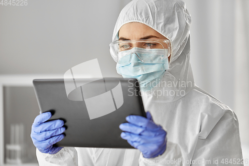 Image of doctor in protective wear with tablet computer