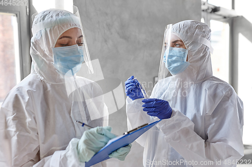 Image of doctors in medical mask and shield with clipboard