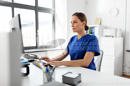 Image of doctor or nurse with computer working at hospital