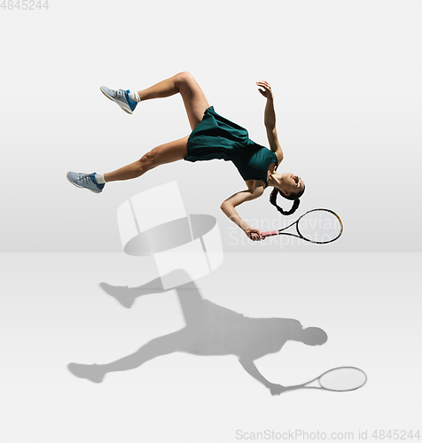 Image of Young caucasian professional sportswoman levitating, flying while playing tennis isolated on white background