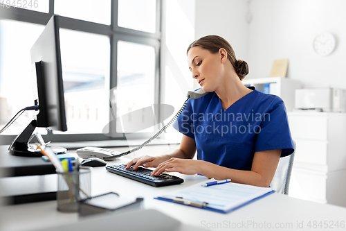 Image of doctor with computer calling on phone at hospital