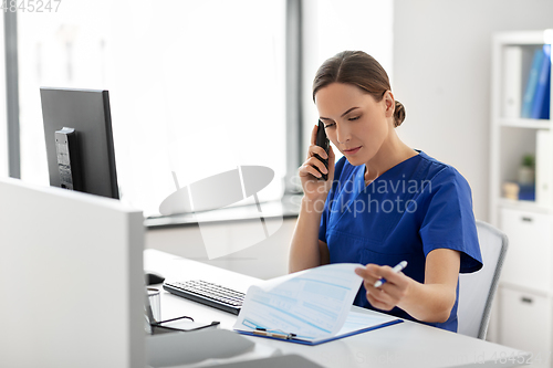 Image of doctor with computer calling on phone at hospital