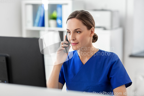 Image of doctor with computer calling on phone at hospital