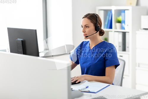 Image of doctor with headset and computer at hospital