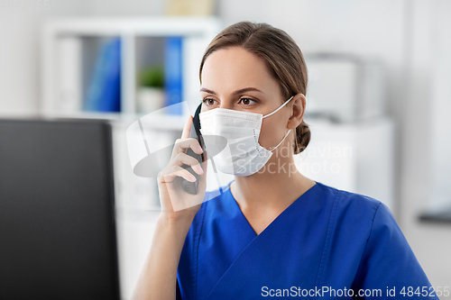 Image of doctor with computer calling on phone at hospital