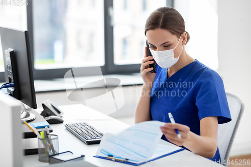 Image of doctor with computer calling on phone at hospital