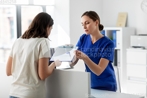 Image of doctor with clipboard and patient at hospital