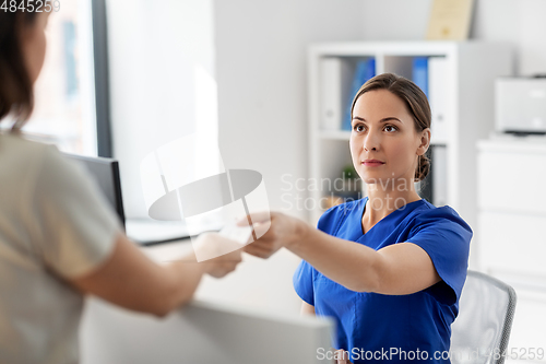 Image of doctor and patient with prescription at hospital