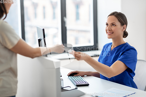 Image of doctor and patient with credit card at hospital