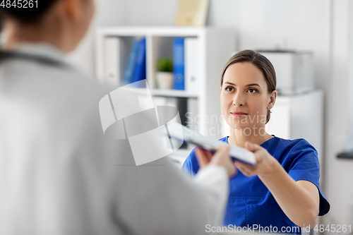 Image of doctor and nurse with clipboard at hospital