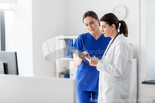 Image of doctor and nurse with clipboard at hospital