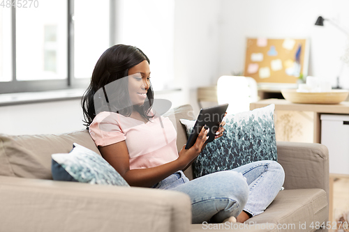 Image of african american woman with tablet pc at home