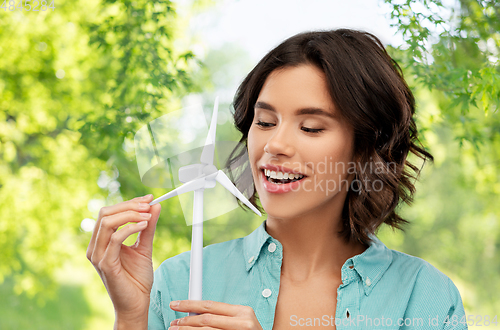 Image of happy smiling young woman with toy wind turbine