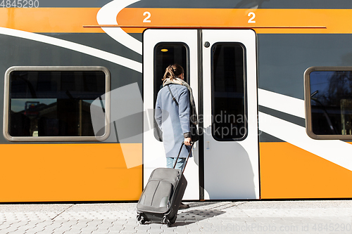 Image of woman with suitcase at railway station