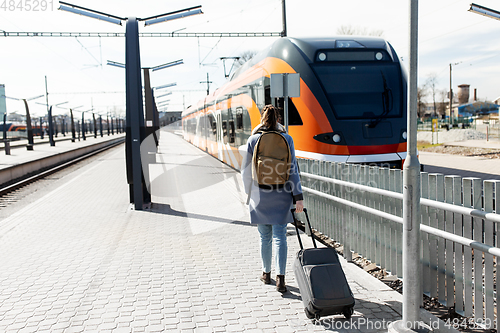 Image of woman with travel bag on railway station