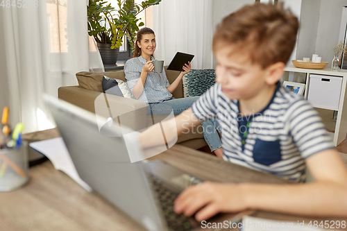 Image of mother with tablet pc and son learning at home