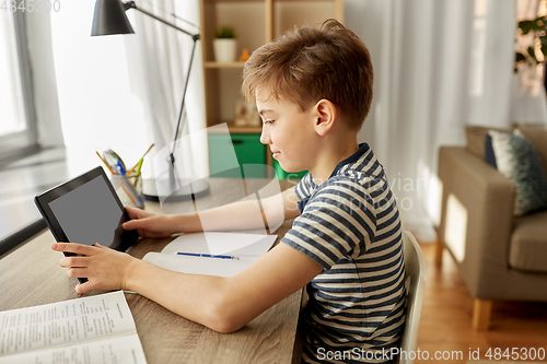 Image of student boy with tablet computer learning at home