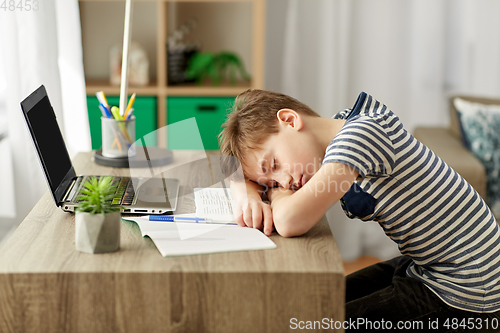 Image of tired student boy sleeping on desk at home