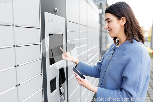 Image of woman with smartphone at automated parcel machine