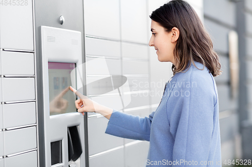 Image of smiling woman using automated parcel machine