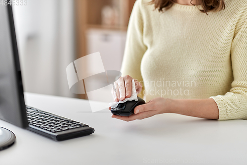 Image of close up of woman cleaning computer mouse