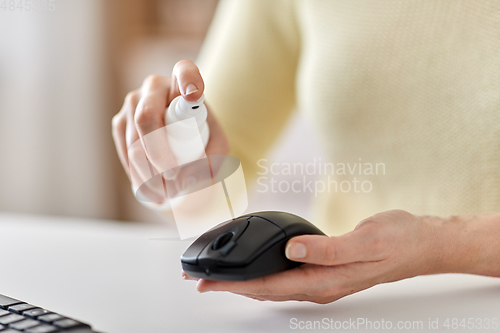 Image of close up of woman cleaning computer mouse