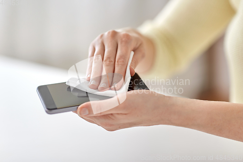 Image of close up of hands cleaning smartphone with tissue