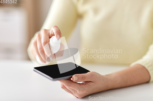 Image of close up of woman hands cleaning smartphone