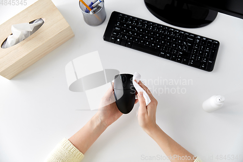 Image of close up of woman cleaning computer mouse