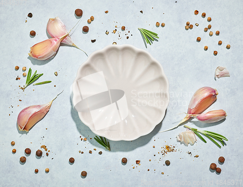Image of white plate on various spices background