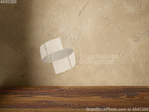 Image of beige color wall and wooden table