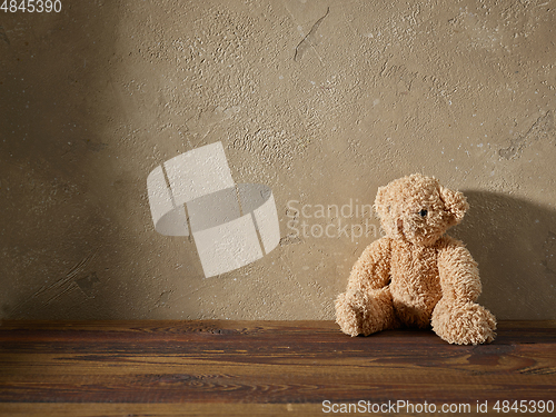 Image of old teddy bear on a wooden shelf