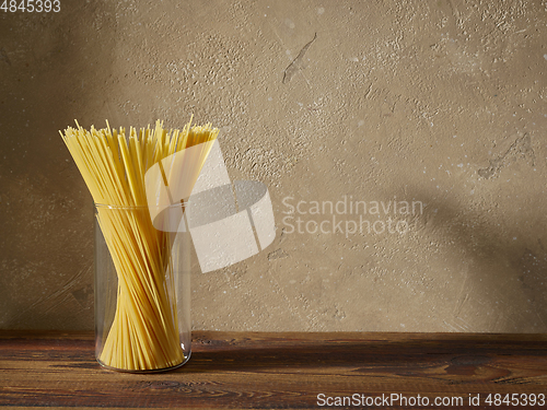 Image of spaghetti pasta on brown wooden shelf