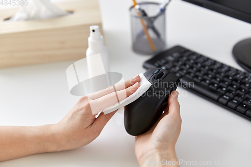 Image of close up of woman cleaning computer mouse