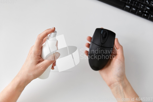 Image of close up of woman cleaning computer mouse