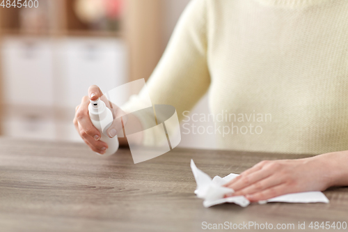 Image of close up of woman cleaning table at home