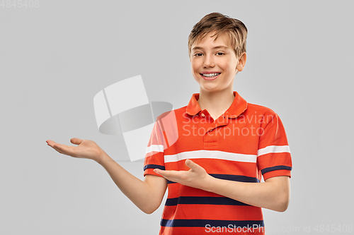 Image of smiling boy showing something invisible