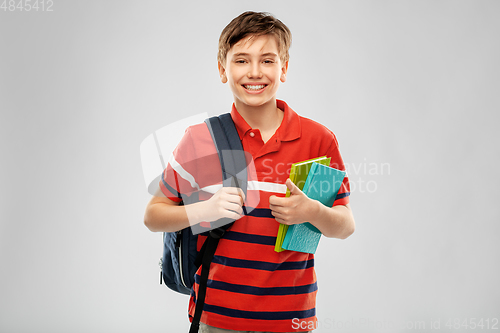 Image of smiling student boy with backpack and books