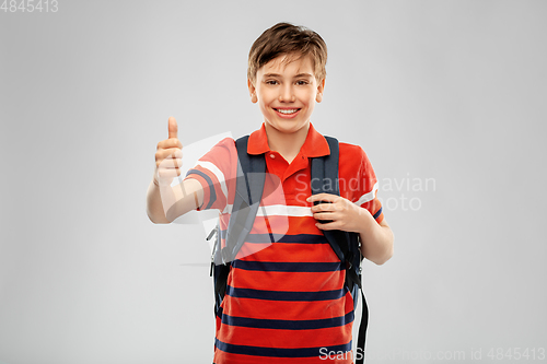 Image of happy student boy with backpack showing thumbs up